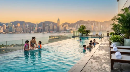 Luxury hotel rooftop pool in Hong Kong with families and children enjoying swimming with Victoria Harbour skyline in background