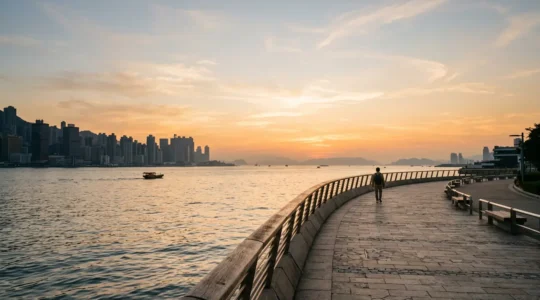Wide panoramic view of Victoria Harbour waterfront promenade with Hong Kong skyline in background