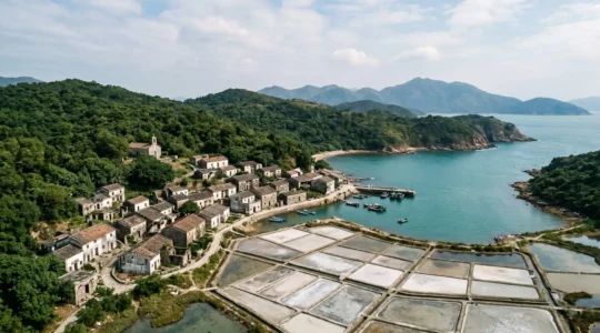 Aerial view of abandoned Hakka village on remote Hong Kong island with traditional salt pans and weathered stone houses