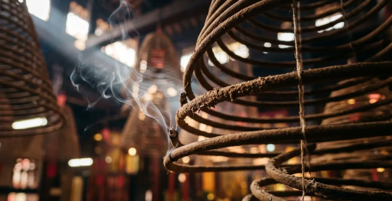 Spiral incense coils catching soft natural temple light creating atmospheric smoke patterns in traditional Chinese worship hall interior