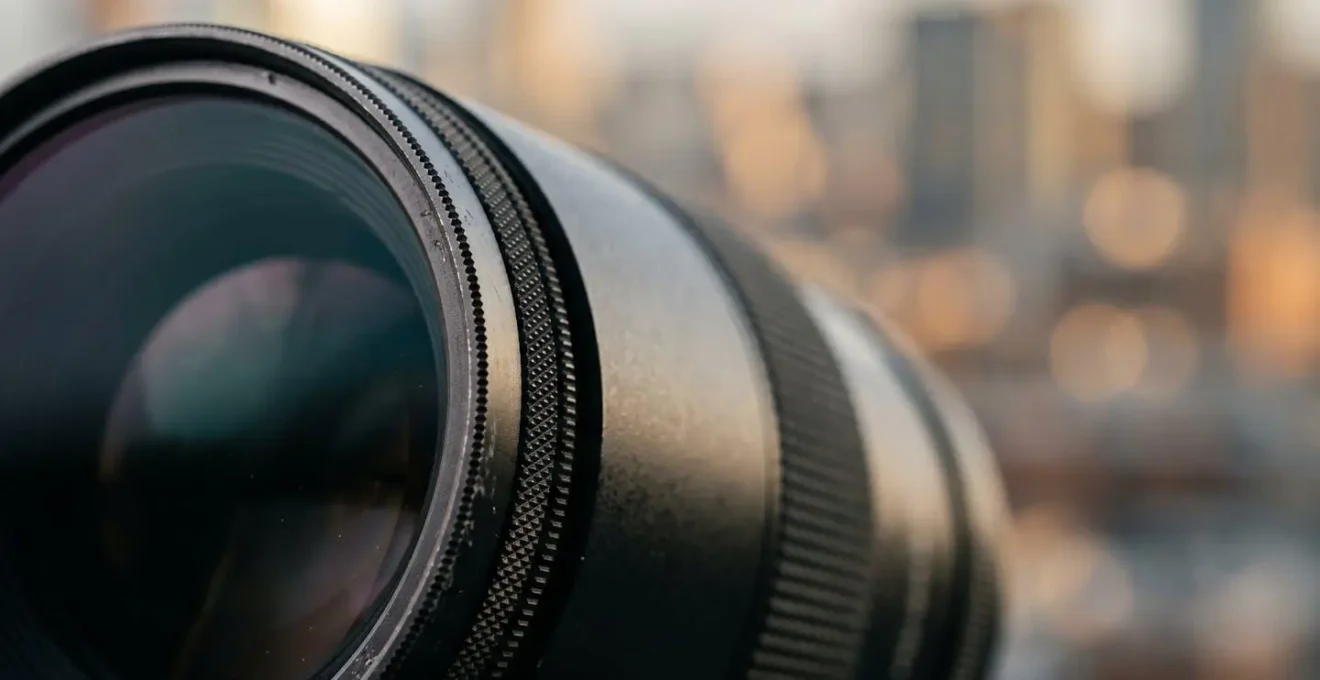 Close-up view of camera lens with circular polarizing filter showing enhanced color depth against hazy urban backdrop