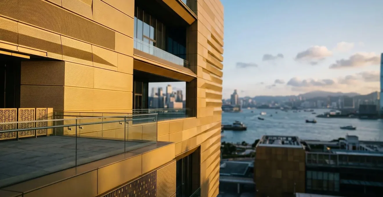 Architectural detail of Hong Kong Palace Museum viewing platform with Victoria Harbour and city skyline visible through modern geometric frames
