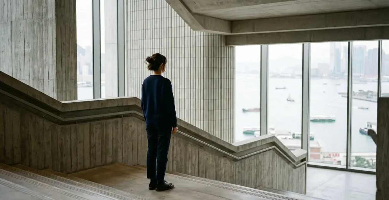 Visitor experiencing the grand architectural scale and natural light of M+ Museum's exhibition spaces